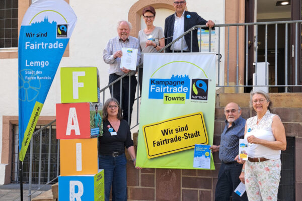 Sie alle freuen sich über 10 Jahr Fairtrade-Stadt Lemgo: (auf der Treppe v.l.) Sprecher Helmut Kohorst, Geschäftsführerin der Initiative Ute Koczy, Bürgermeister Markus Baier, (vor der Treppe v.l.) AWO Petra Junghans, Klemens Gewies vom Lemgoer Weltladen und Nora Albrecht von der Kirchengemeinde St. Nicolai.