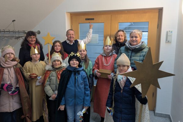 Gemeindereferentin Ursula Kuhfuß, Bürgermeister Mario Hecker und Pastor Thorsten Rosenau [hinten, von links] mit den Sternsingern